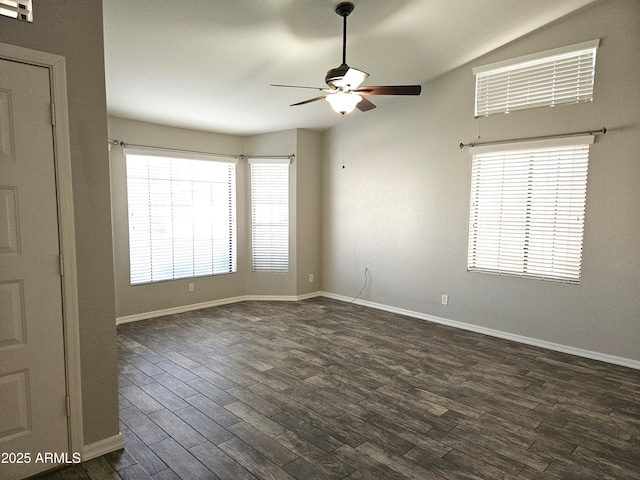 empty room featuring dark wood-type flooring, ceiling fan, and baseboards