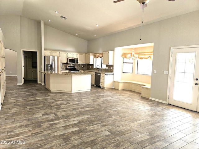 kitchen featuring tasteful backsplash, visible vents, dark wood finished floors, a kitchen island, and stainless steel appliances