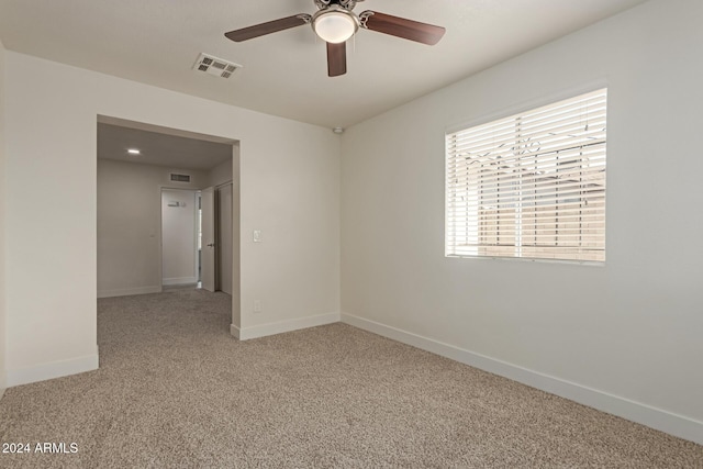 carpeted spare room featuring ceiling fan