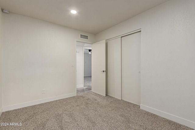 unfurnished bedroom featuring carpet flooring and a closet