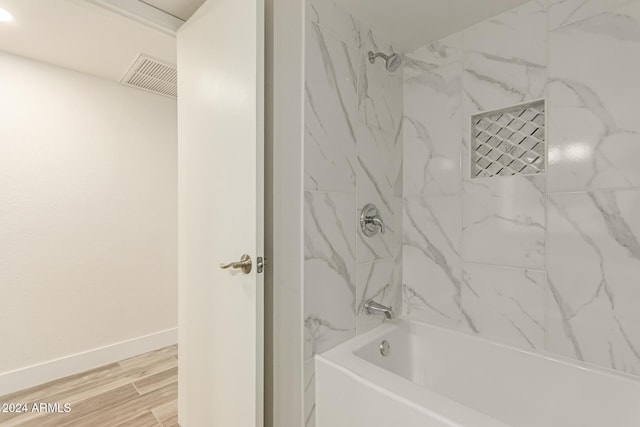 bathroom featuring hardwood / wood-style flooring and tiled shower / bath