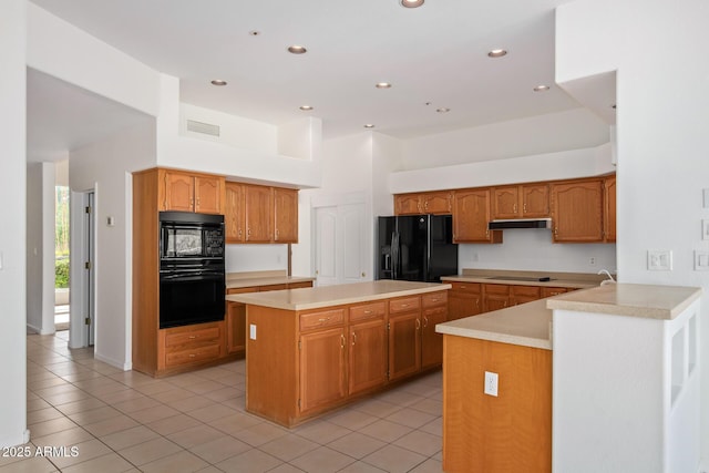 kitchen featuring light countertops, visible vents, light tile patterned floors, and black appliances