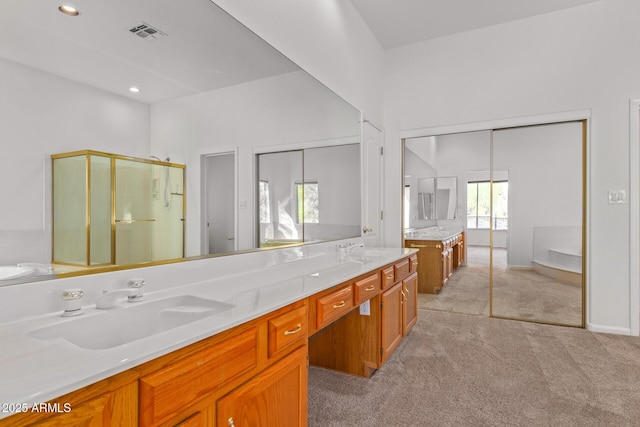 bathroom with double vanity, a sink, visible vents, and a stall shower