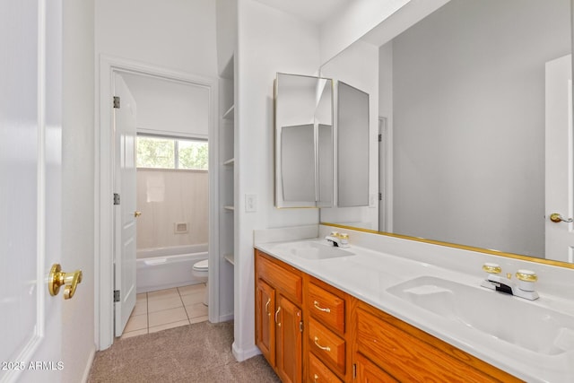 bathroom featuring toilet, tile patterned floors, a sink, and double vanity