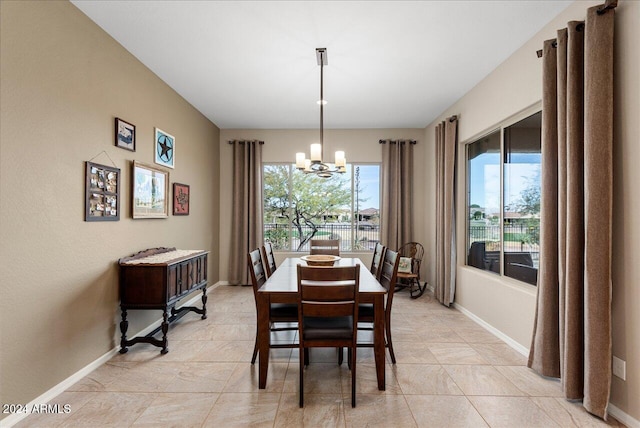 dining area with light tile patterned floors and an inviting chandelier