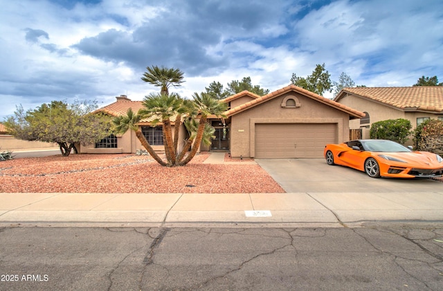 view of front of home with stucco siding, concrete driveway, an attached garage, and a tiled roof