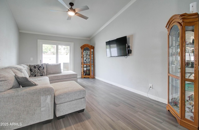 living area featuring vaulted ceiling, ornamental molding, ceiling fan, and wood finished floors