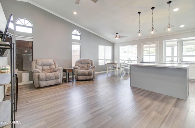 living room with baseboards, ceiling fan, ornamental molding, light wood-style flooring, and high vaulted ceiling