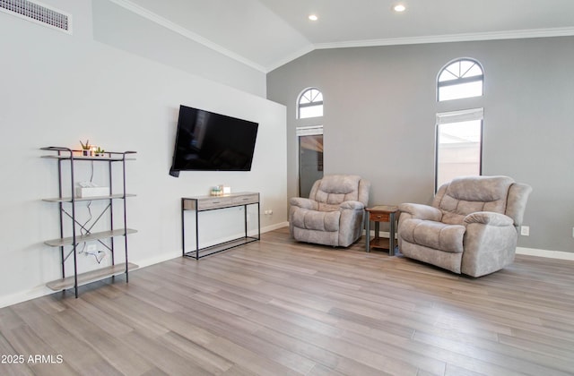 sitting room featuring a wealth of natural light, visible vents, ornamental molding, and wood finished floors