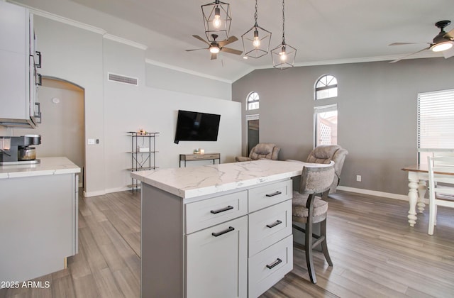 kitchen with open floor plan, light wood-style floors, ceiling fan, and crown molding