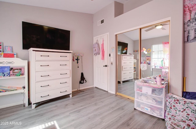 bedroom with visible vents, baseboards, vaulted ceiling, light wood-style floors, and a closet