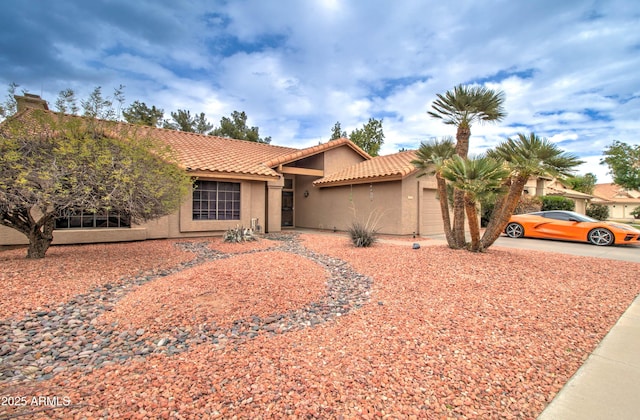 view of front of house featuring stucco siding, a tiled roof, an attached garage, and concrete driveway