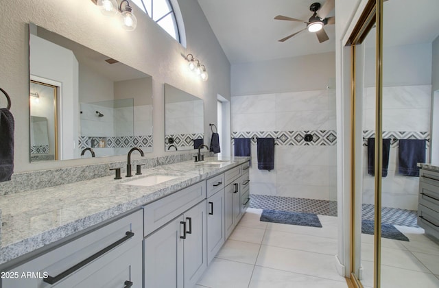 full bath with double vanity, a walk in shower, a ceiling fan, and a sink