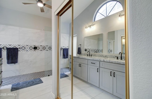 full bathroom featuring double vanity, ceiling fan, walk in shower, and a sink