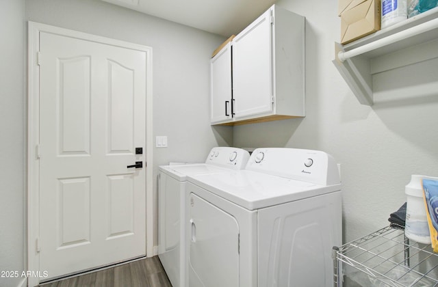 laundry area with cabinet space, dark wood finished floors, and washing machine and clothes dryer