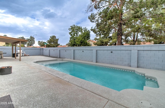 view of pool with a fenced in pool, a patio, a grill, and a fenced backyard