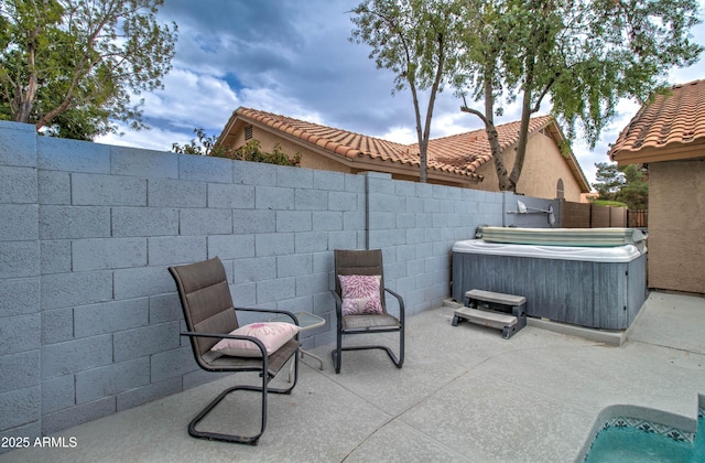 view of patio / terrace with fence and a hot tub