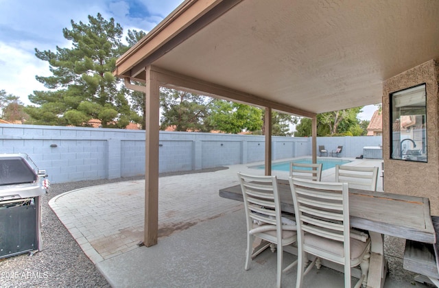 view of patio / terrace featuring outdoor dining area, a fenced in pool, a grill, and a fenced backyard