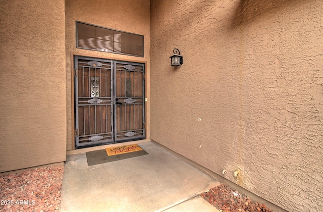 doorway to property featuring stucco siding