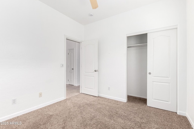 unfurnished bedroom with ceiling fan, light colored carpet, and a closet