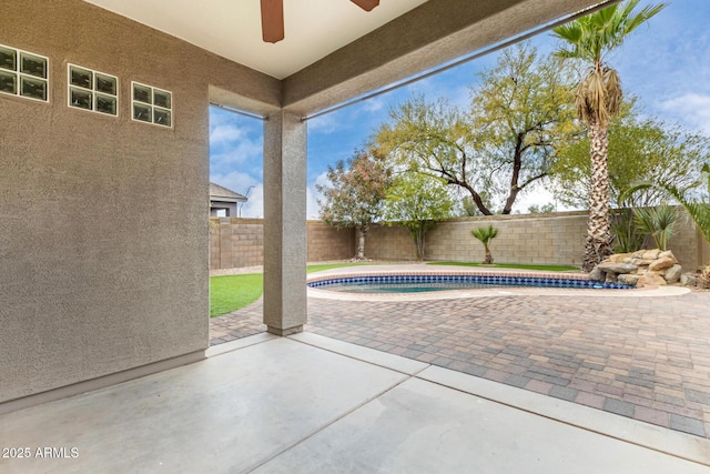 view of swimming pool featuring ceiling fan and a patio area