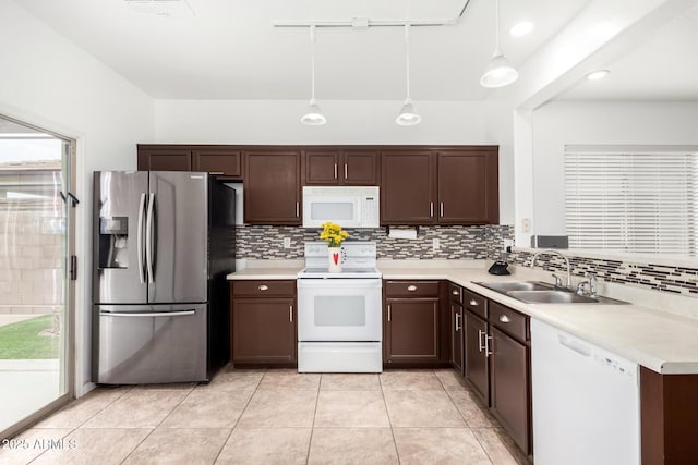 kitchen with tasteful backsplash, sink, white appliances, and decorative light fixtures