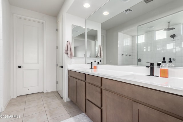 bathroom featuring a tile shower, tile patterned floors, and vanity