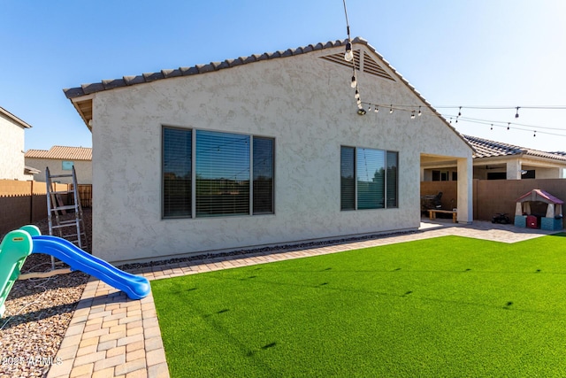 back of property featuring a patio area and a yard