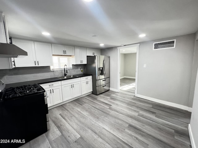 kitchen with black stove, sink, stainless steel refrigerator with ice dispenser, light hardwood / wood-style floors, and white cabinetry