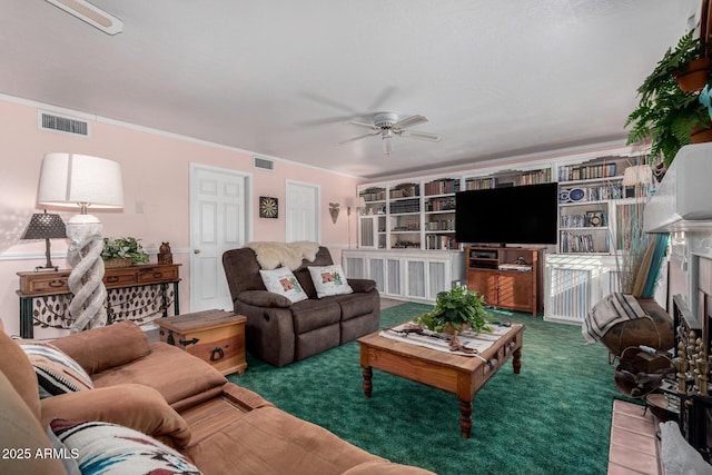 living room featuring a ceiling fan, visible vents, a fireplace, and crown molding