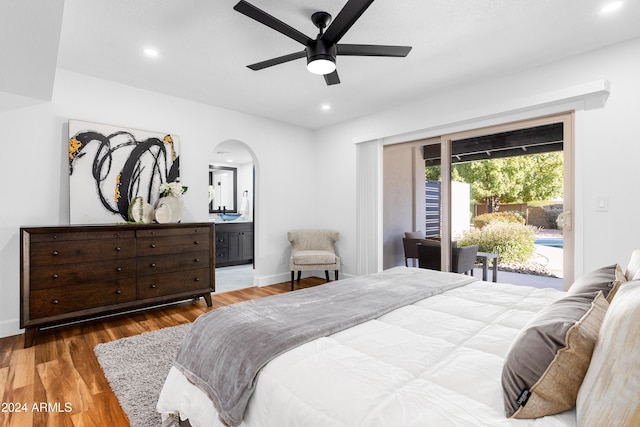 bedroom featuring access to exterior, ensuite bathroom, dark wood-type flooring, and ceiling fan