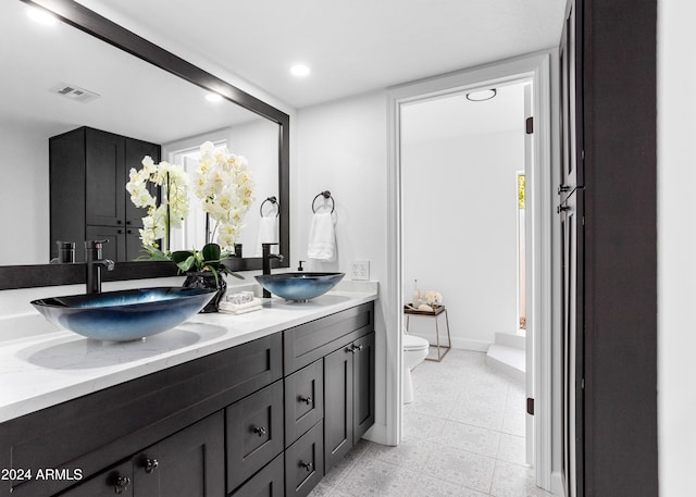 bathroom with vanity, tile patterned flooring, and toilet