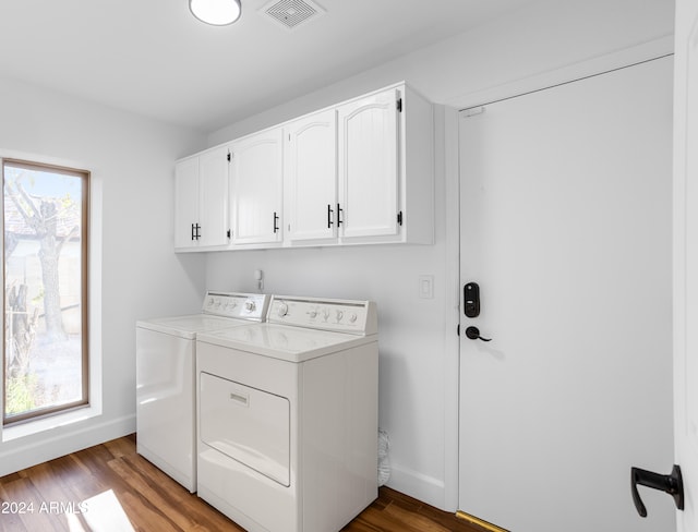 clothes washing area featuring light hardwood / wood-style floors, cabinets, a wealth of natural light, and separate washer and dryer