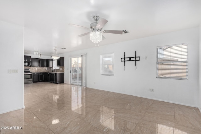 unfurnished living room featuring ceiling fan, a healthy amount of sunlight, and sink