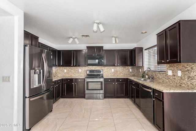 kitchen with sink, dark brown cabinets, light stone countertops, decorative backsplash, and black appliances