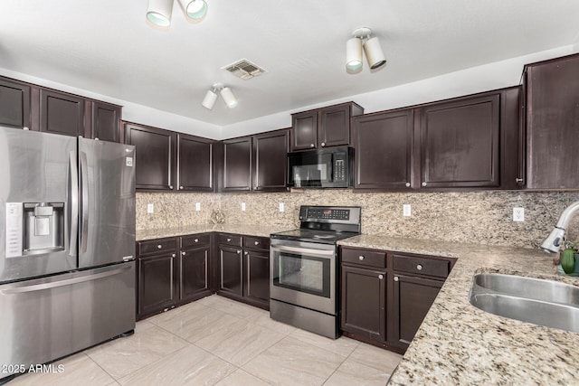 kitchen featuring tasteful backsplash, sink, stainless steel appliances, and dark brown cabinetry