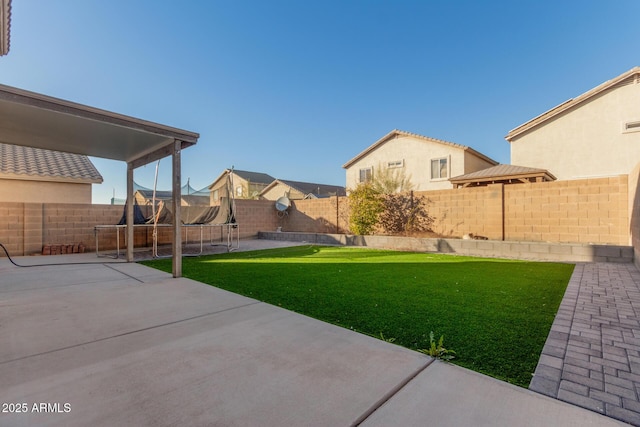 view of yard featuring a patio and a trampoline