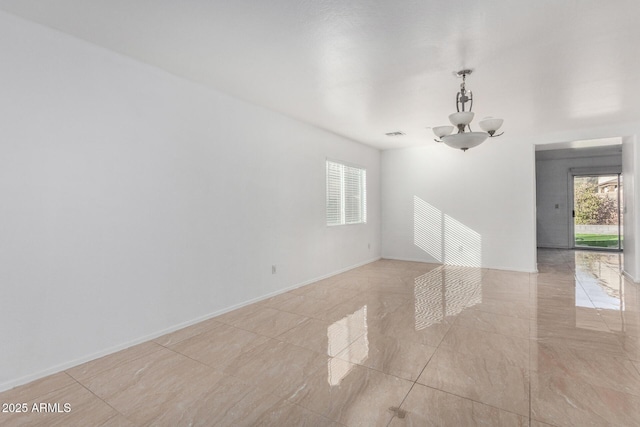 spare room with an inviting chandelier