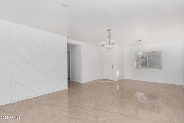 spare room featuring a chandelier