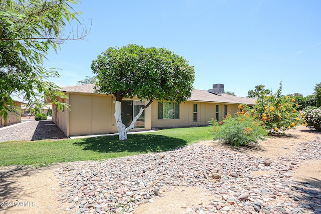 rear view of house featuring a lawn