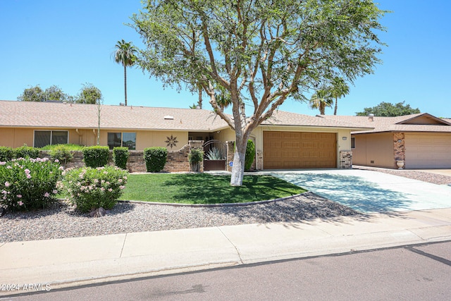 ranch-style home featuring a front yard and a garage