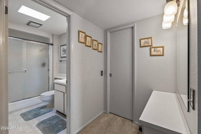 bathroom with vanity, an enclosed shower, a textured ceiling, and toilet