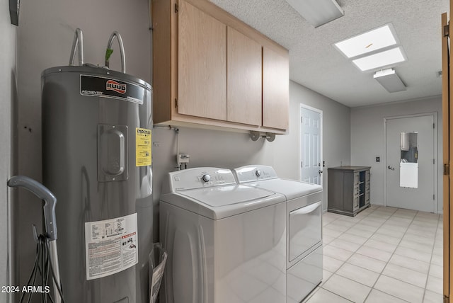 laundry room featuring washing machine and dryer, a textured ceiling, cabinets, light tile patterned floors, and electric water heater