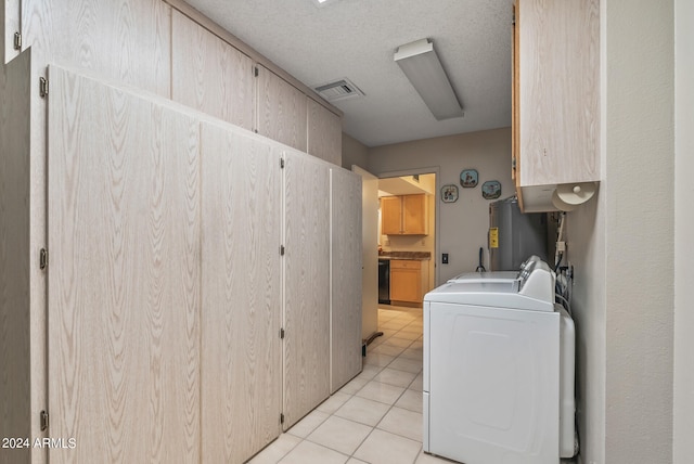 clothes washing area with cabinets, water heater, light tile patterned flooring, and washing machine and dryer