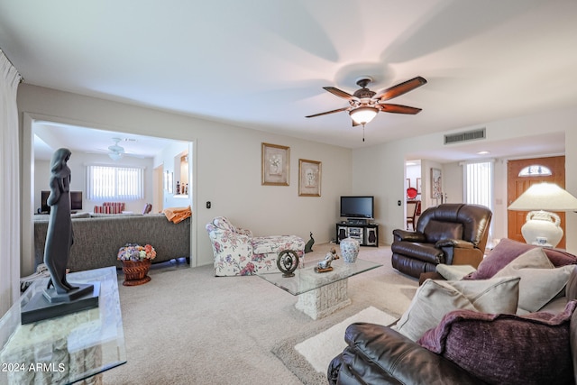 carpeted living room with ceiling fan