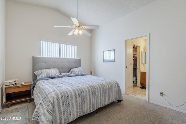 bedroom with a textured ceiling, vaulted ceiling, light colored carpet, and ceiling fan