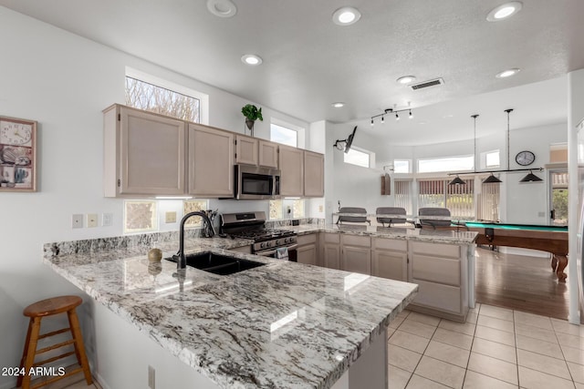 kitchen with pool table, a healthy amount of sunlight, kitchen peninsula, and appliances with stainless steel finishes