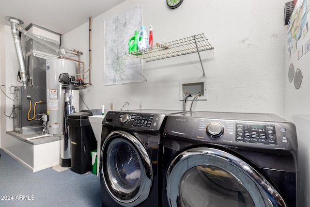 clothes washing area featuring washer and clothes dryer, gas water heater, carpet floors, and heating unit