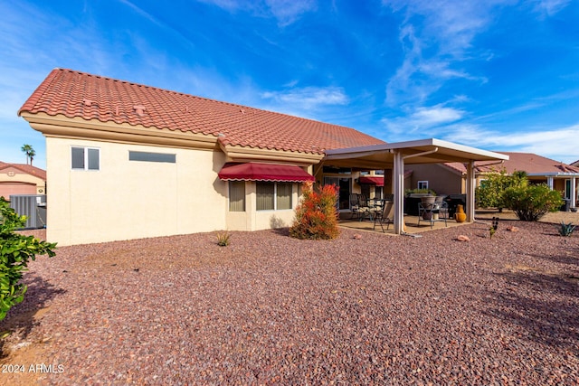 back of house with central air condition unit and a patio