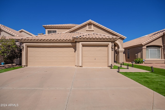 mediterranean / spanish house with a front yard and a garage